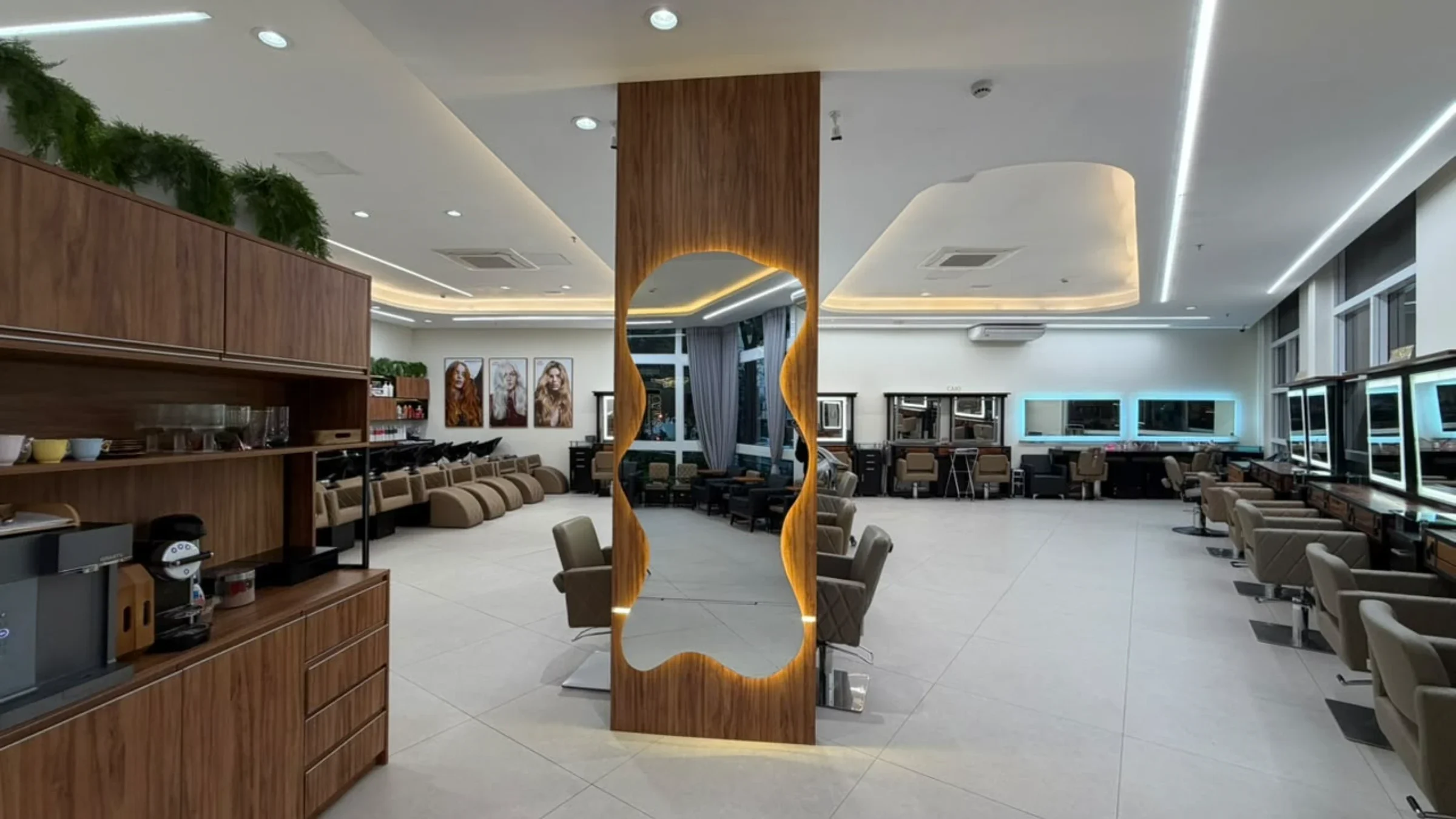 Salao amplo do IT com espelho organico retroiluminado, estacoes nomeadas em dourado e lounge